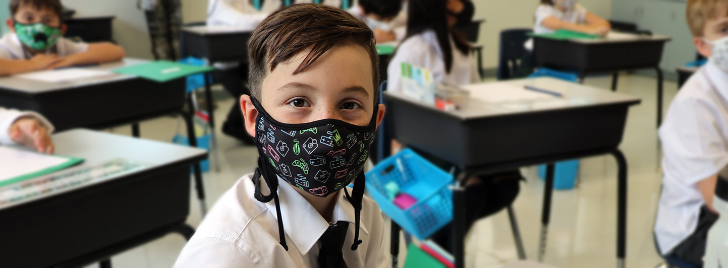Primary aged boy in class with mask on