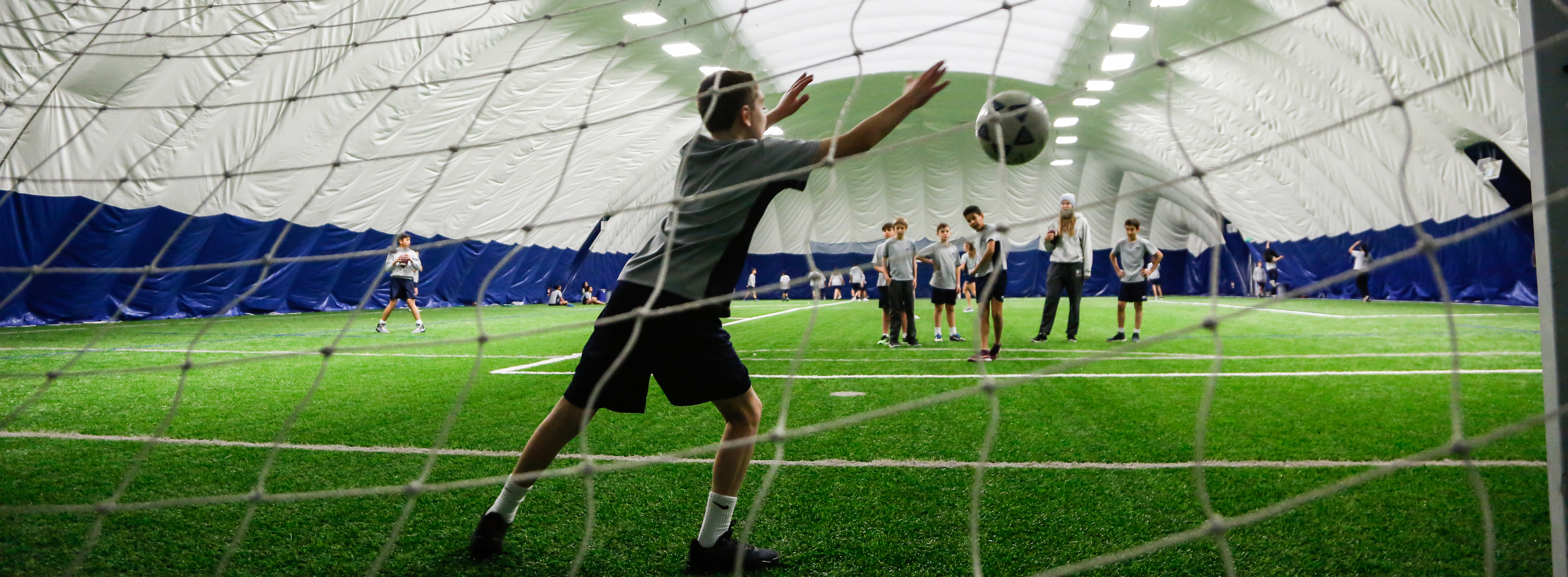 Boys playing indoor soccer in a dome