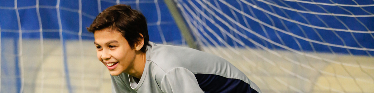 Intermediate Division boy smiling, playing in a soccer game 