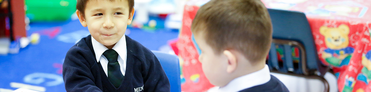 Kindergarten boy learning with classmate