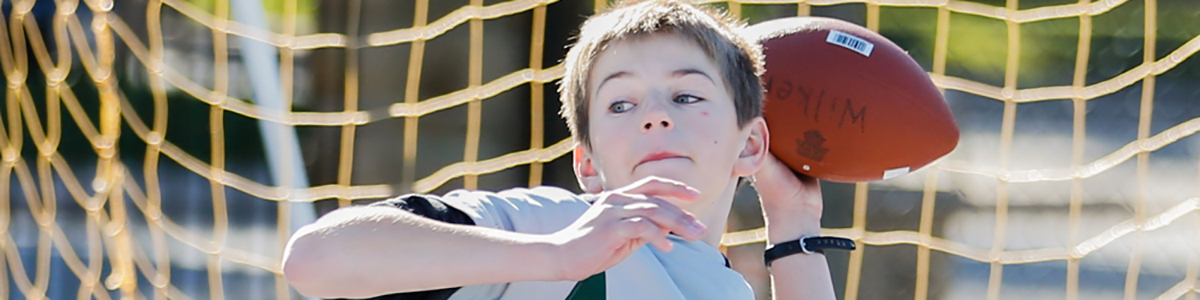 Intermediate Division boy on field throwing a football