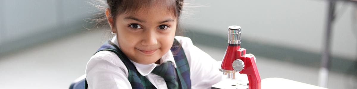 Primary Division child with a microscope