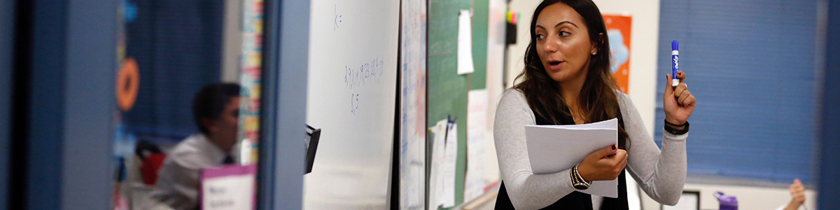 Grade 7 teacher teaching class at the chalkboard